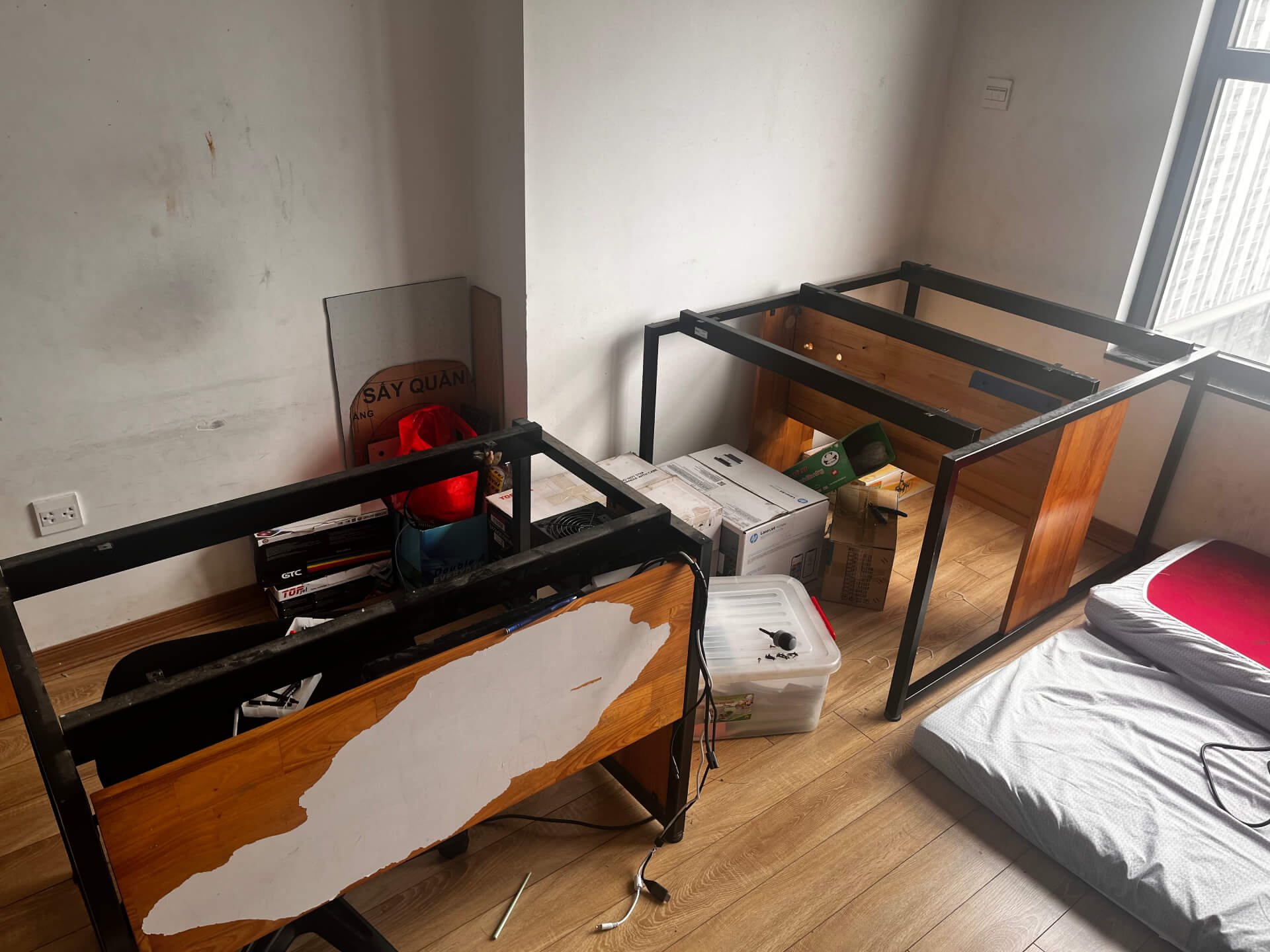 Black metal desk frames with tabletops removed, revealing sturdy construction with wooden side panels intact