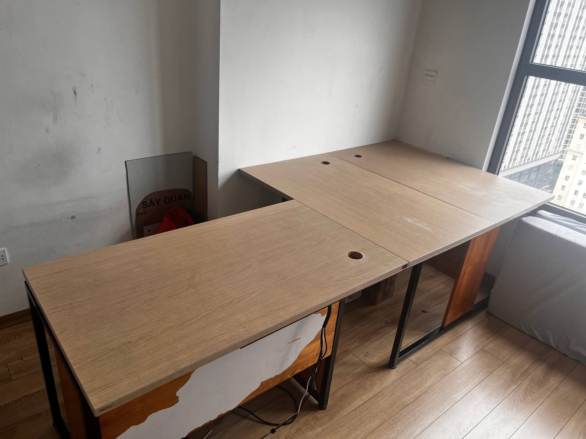 Workshop with three desks showing new flat wooden tabletops properly installed on black metal frames